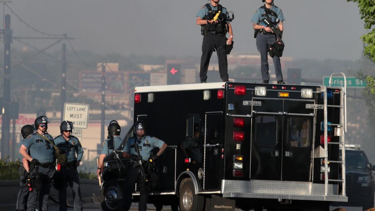 Police stand watch near a protest May 28, 2020 in St. Paul, Minnesota. Today marks the third day of ongoing protests after the police killing of George Floyd. Four Minneapolis police officers have been fired after a video taken by a bystander was posted on social media showing Floyd's neck being pinned to the ground by an officer as he repeatedly said, "I cant breathe." SCOTT OLSON / GETTY IMAGES NORTH AMERICA / Getty Images via AFP
