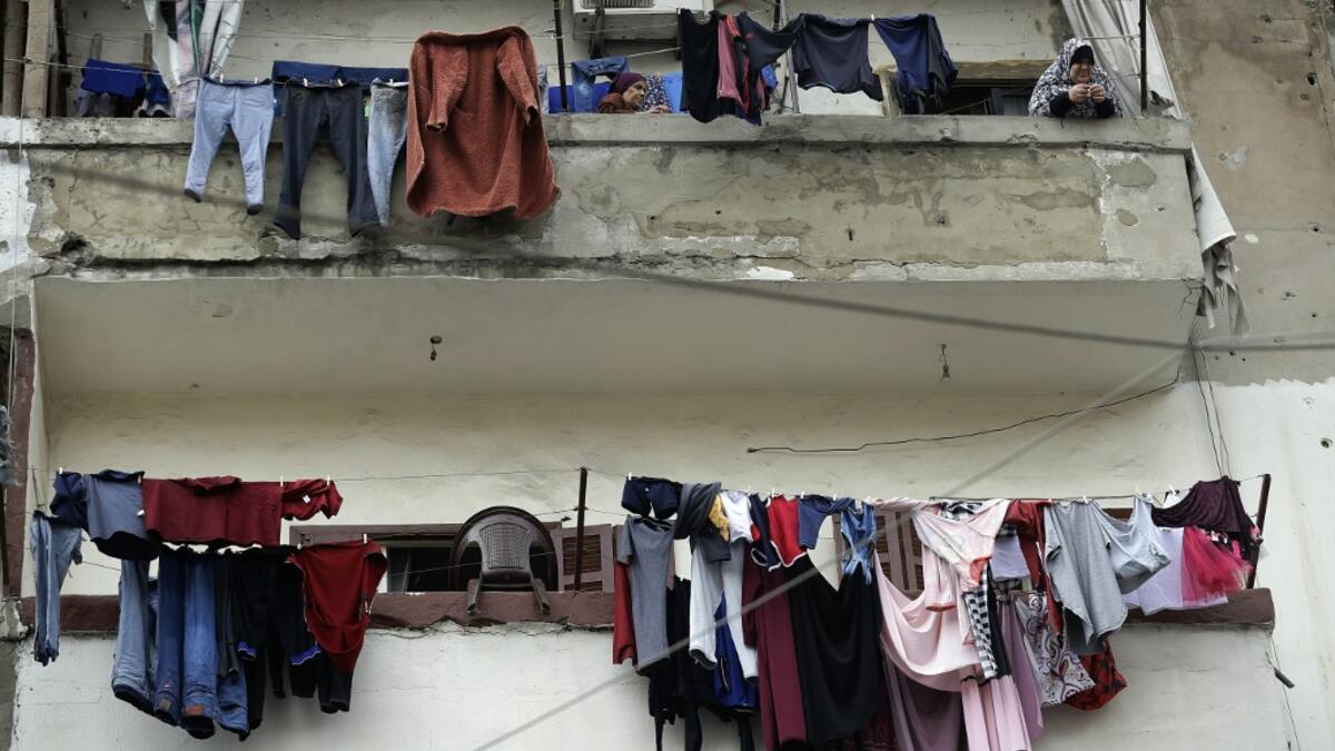 A woman stands next to laundry lines hanging out to dry on a balcony in the Bab al-Tabbaneh neighbourhood of Lebanon's northern city of Tripoli on June 3, 2020. Thousands of residents of Lebanon's northern Tripoli struggle to put food on the table, as the country's worst economic crisis in decades has picked up in speed in recent weeks, with food prices rising by more than 70 percent since the autumn. Inflation has been a blow in the country where more than 45 percent of the country's population now lives b