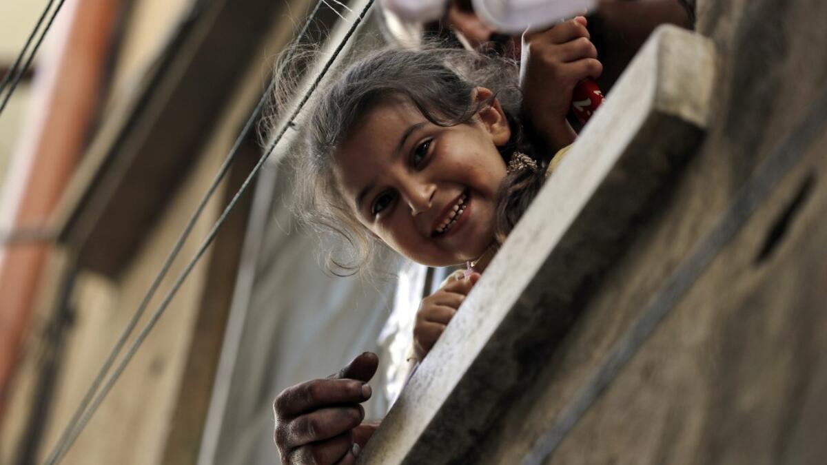 A girl peeks out of a window in the Bab al-Tabbaneh neighbourhood of Lebanon's northern city of Tripoli on June 3, 2020. Thousands of residents of Lebanon's northern Tripoli struggle to put food on the table, as the country's worst economic crisis in decades has picked up in speed in recent weeks, with food prices rising by more than 70 percent since the autumn. Inflation has been a blow in the country where more than 45 percent of the country's population now lives below the poverty line, and more than 35