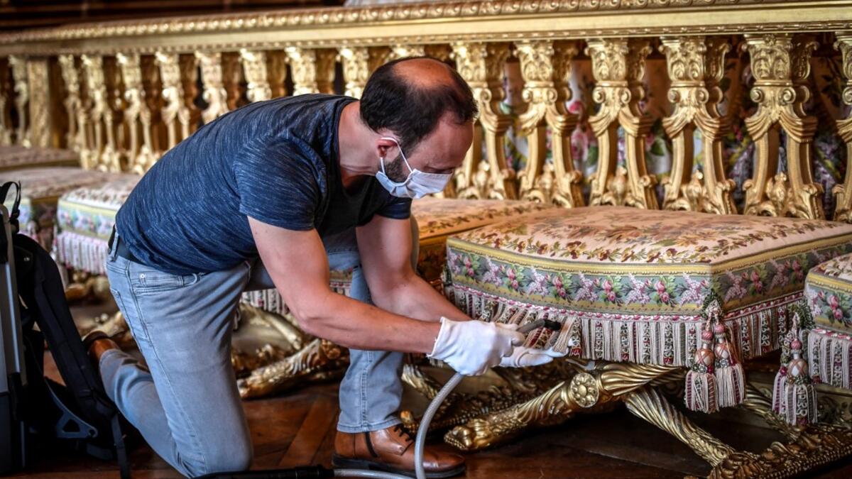 A worker cleans the Queen bedroom (Chambre de la Reine) at the Chateau de Versailles (Palace of Versailles) in Versailles near Paris, on June 5, 2020 on the eve of it re-opening after 82 days of closure due to the novel coronavirus (COVID-19) outbreak. The Palace of Versailles -- France's big tourist attraction with nearly 10 million tourists a year - will open on June 6 with no US or Asia tourists who represent 30% of its visitors. STEPHANE DE SAKUTIN / AFP