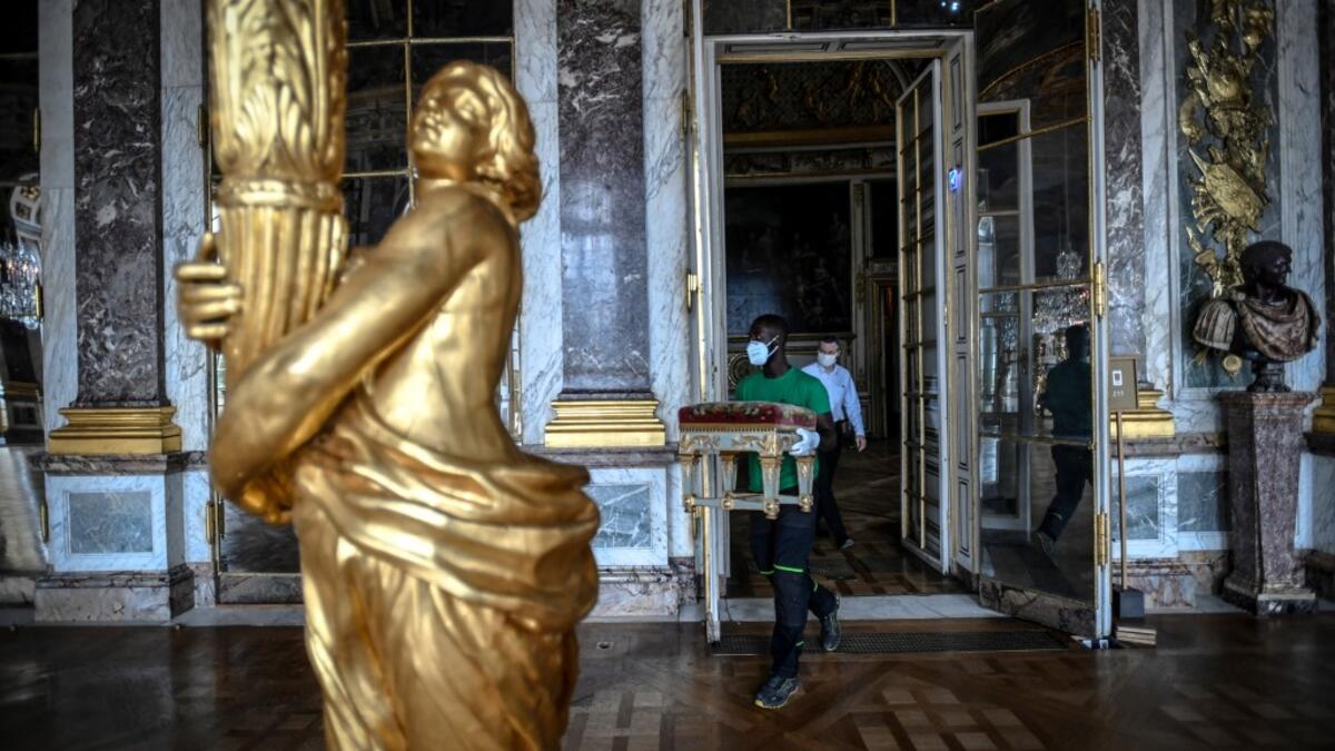 A worker carries furniture in the Galerie des Glaces (Hall of Mirrors) at the Chateau de Versailles (Palace of Versailles) in Versailles near Paris, on June 5, 2020 on the eve of it re-opening after 82 days of closure due to the novel coronavirus (COVID-19) outbreak. The Palace of Versailles -- France's big tourist attraction with nearly 10 million tourists a year - will open on June 6 with no US or Asia tourists who represent 30% of its visitors. STEPHANE DE SAKUTIN / AFP