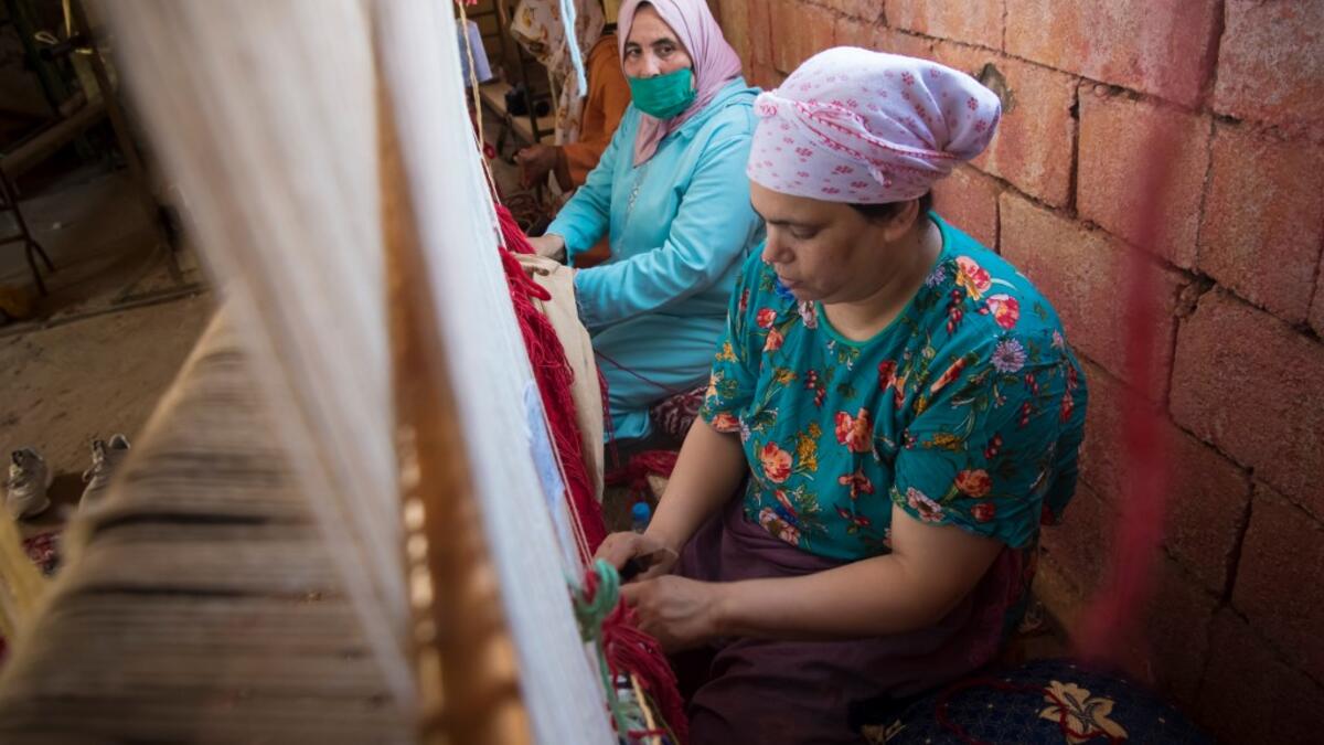 Moroccan rug weavers create a carpet at a workshop in the city of Sale, north of the capital Rabat, on June 3, 2020, during the novel coronavirus pandemic. Artisans in Morocco have been starved of income for almost three months because of the COVID-19 pandemic. The crafts industry represents some seven percent of GDP, with an export turnover last year of nearly 1 billion dirhams ($100 million). FADEL SENNA / AFP