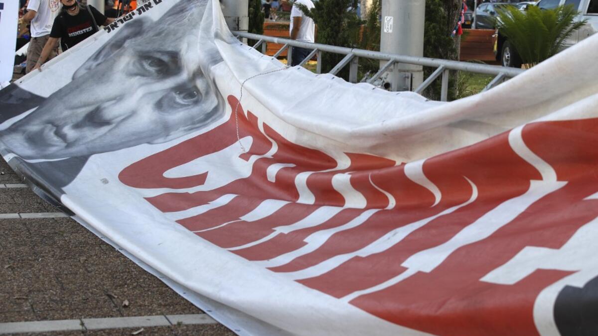 A protester prepares a placard bearing the portrait of Israeli Prime Minister Benjamin Netanyahu during a protest in Tel Aviv's Rabin Square on June 6, 2020, to denounce Israel's plan to annex parts of the occupied West Bank. JACK GUEZ / AFP