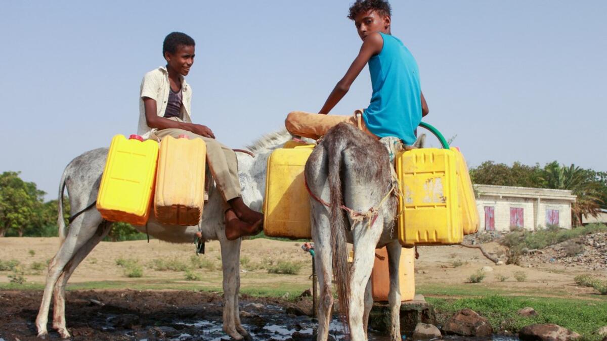 Yemeni children riding donkeys fill their jerrycans with water from a cistern at a make-shift camp for the internally displaced, in the northern Hajjah province, on June 7, 2020, amid a severe shortage of water. ESSA AHMED / AFP