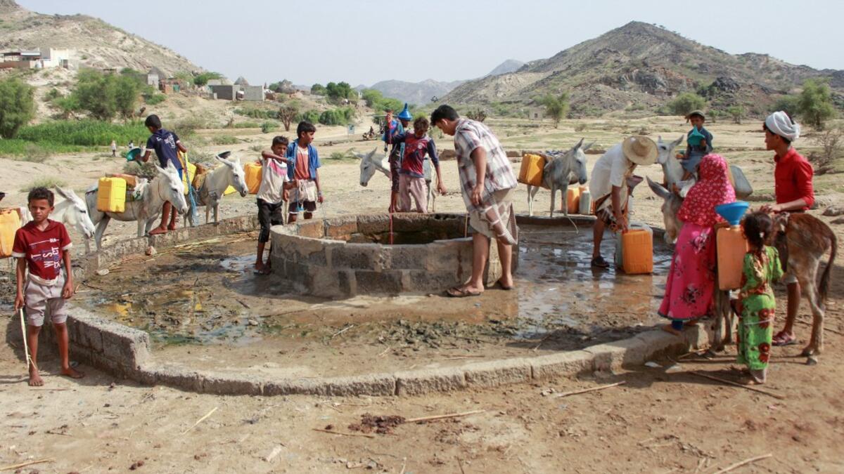 Yemenis fill their jerrycans carried by donkeys, with water from a cistern at a make-shift camp for the internally displaced, in the northern Hajjah province, on June 7, 2020, amid a severe shortage of water. ESSA AHMED / AFP