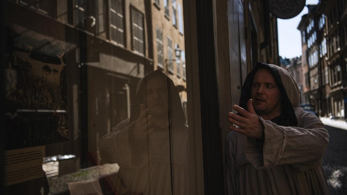 Tour guide Mike Anderson takes visitors on May 30 ,2020 on a 'plague walk', taking them around sites in Stockholm's old town related to pandemics of the plague in the 14th and 18th century, and an outbreak of cholera that hit the city in the mid-19th century. Jonathan NACKSTRAND / AFP