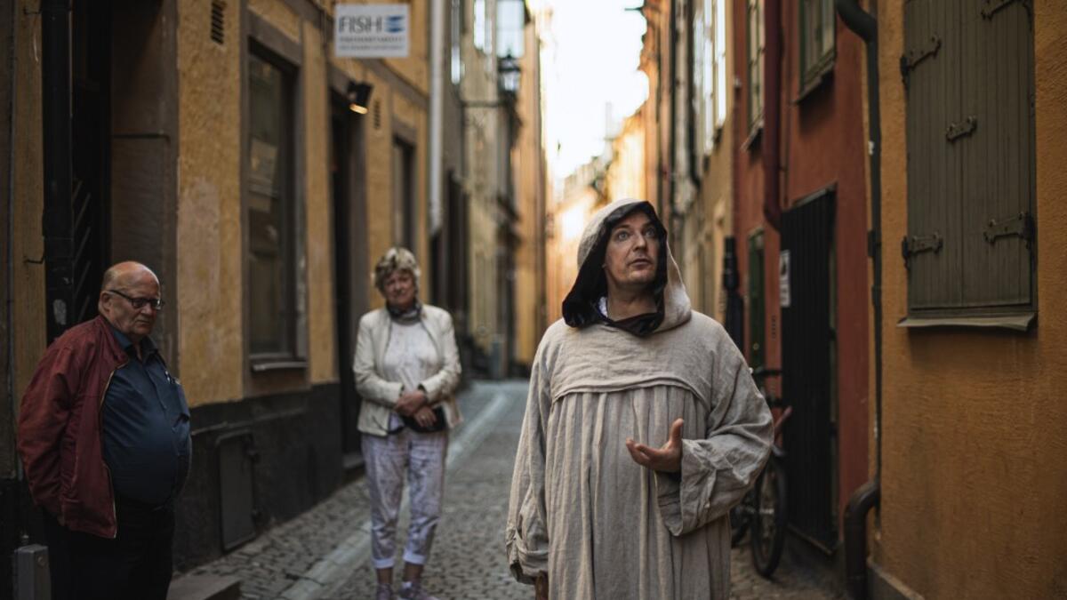 Tour guide Mike Anderson takes visitors on May 30 ,2020 on a 'plague walk', taking them around sites in Stockholm's old town related to pandemics of the plague in the 14th and 18th century, and an outbreak of cholera that hit the city in the mid-19th century. Jonathan NACKSTRAND / AFP