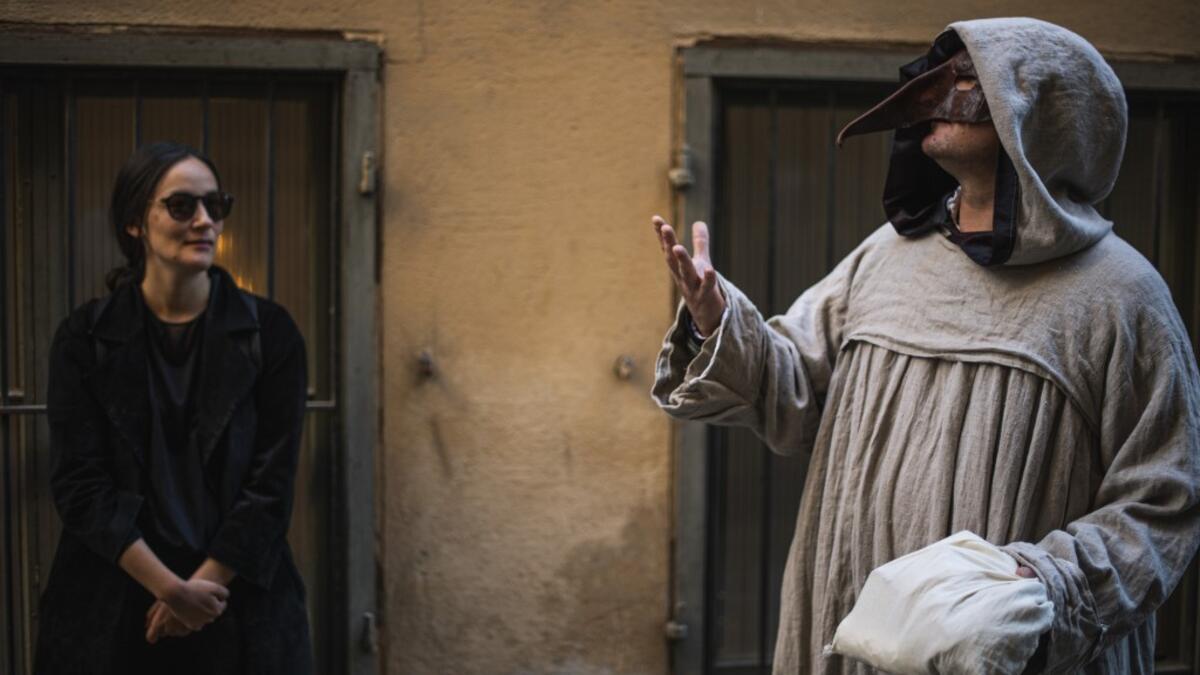 Tour guide Mike Anderson (R) takes visitors on May 30 ,2020 on a 'plague walk', taking them around sites in Stockholm's old town related to pandemics of the plague in the 14th and 18th century, and an outbreak of cholera that hit the city in the mid-19th century. With tourists confined at home and Stockholmers staying away from crowds, one Swedish tour guide is trying to boost his flagging business by offering coronavirus-weary Swedes tours of the city's previous pandemics. AFP