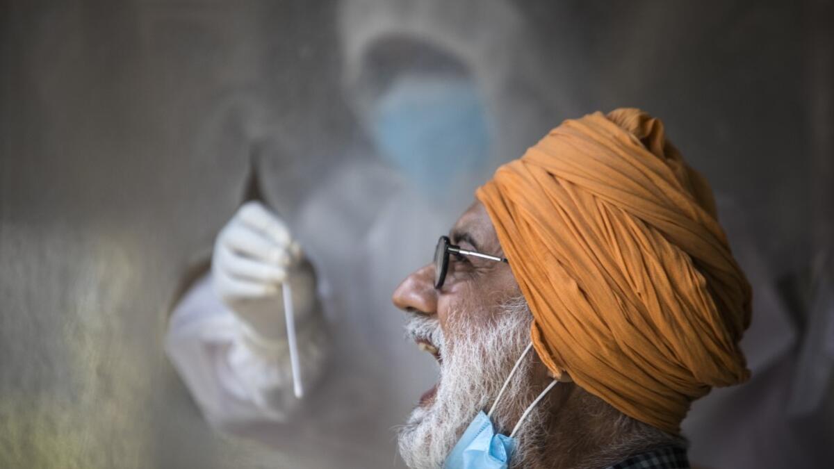 A health official collects a swab sample from a man to test for the COVID-19 coronavirus at a temporary testing center at a hotel after authorities eased restrictions imposed as a preventive measure against the spread of the COVID-19 coronavirus, in New Delhi on June 17, 2020. India's official coronavirus death toll leapt by more than 2,000 on June 17 as the hard-hit country struggles to contain a ballooning health crisis that has overwhelmed hospitals. The news came as Germany urged its nationals in India