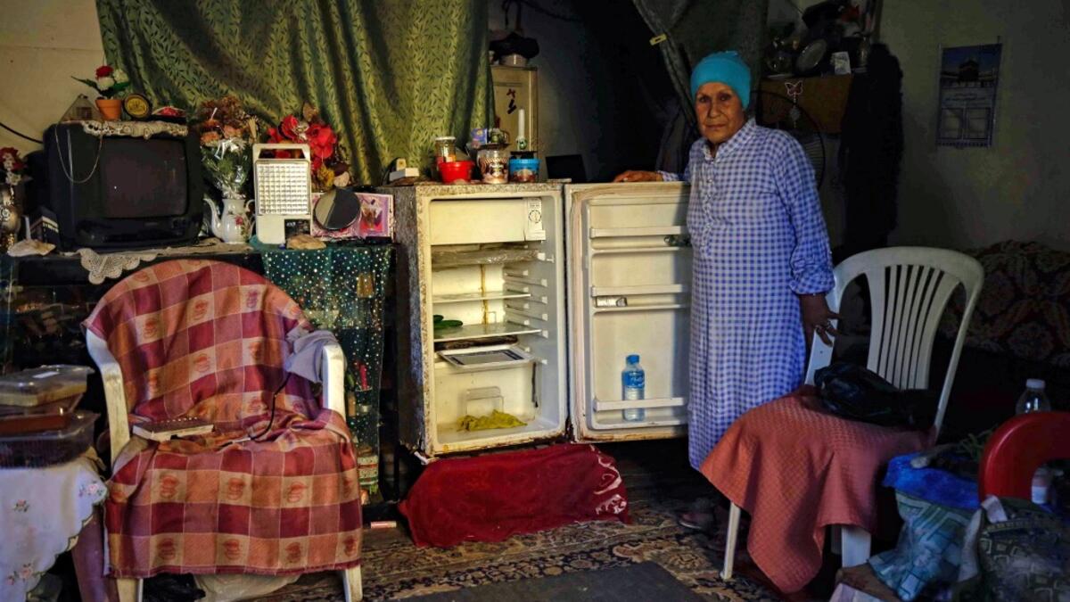 A Lebanese woman stands next to her empty refrigerator in her apartment in the port city of Tripoli north of Beirut on June 17, 2020. Lebanon's economic crisis has led to a collapse of the local currency and purchasing power, plunging whole segments of the population into poverty as exemplified by near-empty fridges in many households. IBRAHIM CHALHOUB / AFP