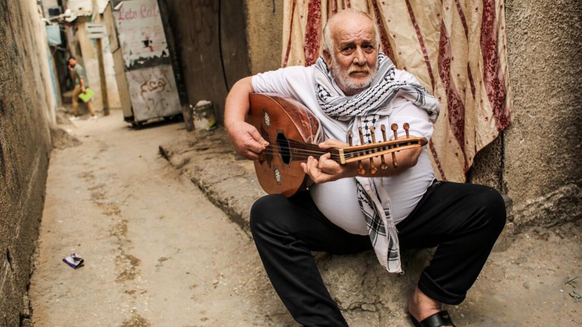 Tawfiq Shanaa, a 66-year-old man, plays the oud as he performs traditional Palestinian songs outside his house in the Rafah camp for Palestinian refugees in the southern Gaza Strip on June 20, 2020. June 20 marks World Refugee Day, a day dedicated by the United Nations General Assembly to raising awareness of the situation of refugees throughout the world. SAID KHATIB / AFP