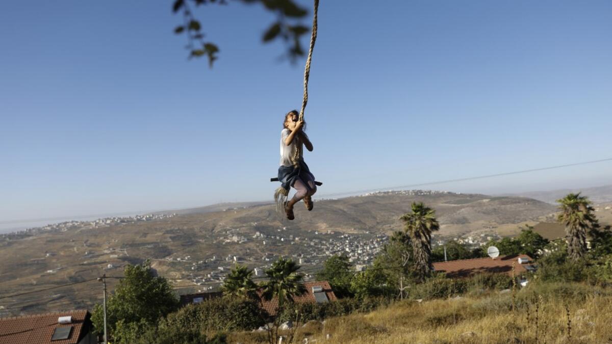 A girl swings at a park in the Israeli Yitzhar settlement south of the Palestinian city of Nablus in the occupied the West Bank on June 22, 2020. The government of Israeli Prime Minister Benjamin Netanyahu has said it could begin the process to annex Jewish settlements in the West Bank as well as the strategic Jordan Valley from July 1.The plan -- endorsed by Washington -- would see the creation of a Palestinian state, but on reduced territory, and without Palestinians' core demand of a capital in east Jeru