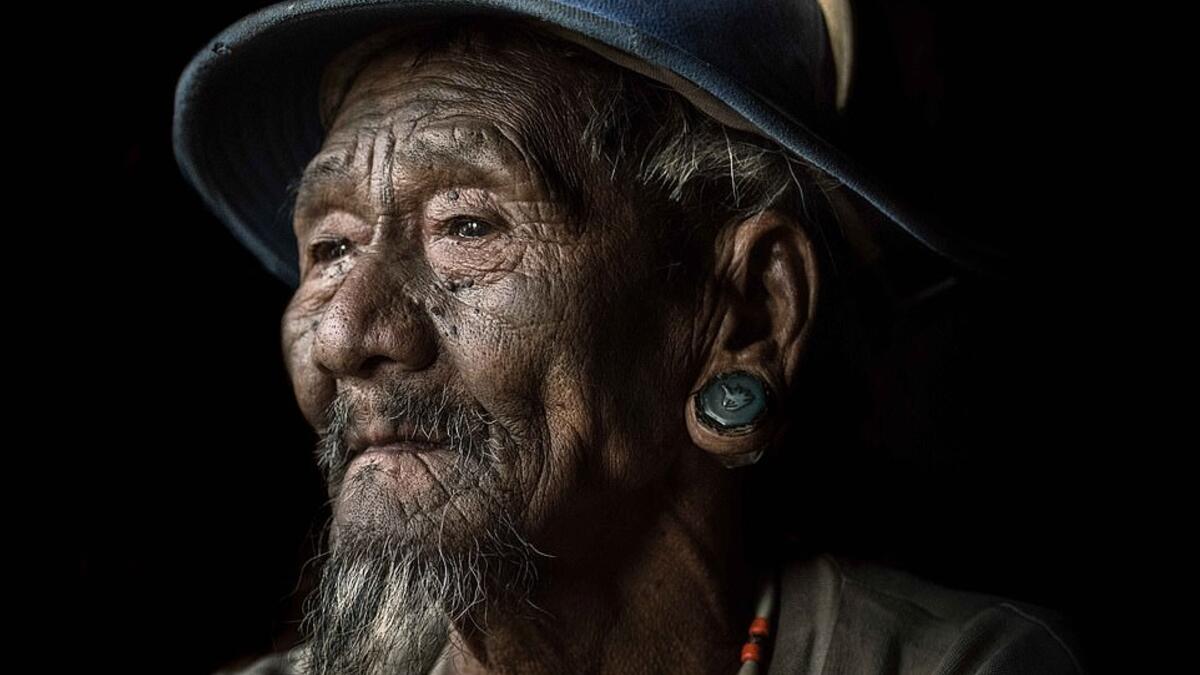 An elderly Konyak tribesman wears thick ear plugs and sports a goatee while dressed in more western clothes than the tribe would have traditionally worn. (Mediadrumimages/ Trevor Cole)