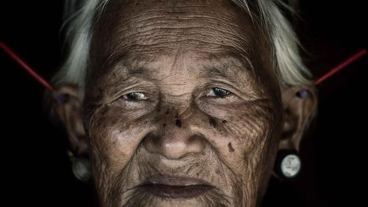 A woman from the Konyak tribe wears plugs in her both her lobes while another set, believed to be made from bone, protrude at jagged angles from the top of her ears. (Mediadrumimages/ Trevor Cole)