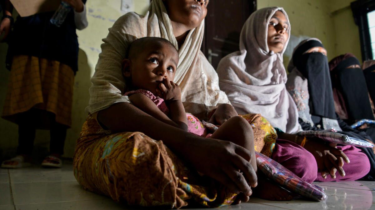 Rohingya people from Myanmar wait for aid at the immigration detention centre in Lhokseumawe in Indonesia's North Aceh Regency on June 26, 2020. Nearly 100 Rohingya asylum seekers stranded off the coast of Indonesia were pulled to shore on June 25 by locals angered at the refusal of authorities to give them shelter over coronavirus fears. CHAIDEER MAHYUDDIN / AFP