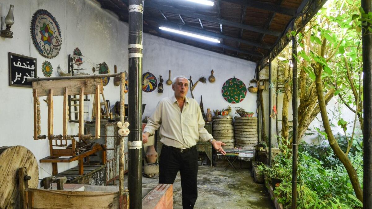 Muhammad Saud, a 65-year-old Syrian silk farmer, handweaves silk threads on a loom at his home workshop in the village of Deir Mama, in west-central Syria on June 22, 2020. MAHER AL MOUNES / AFP