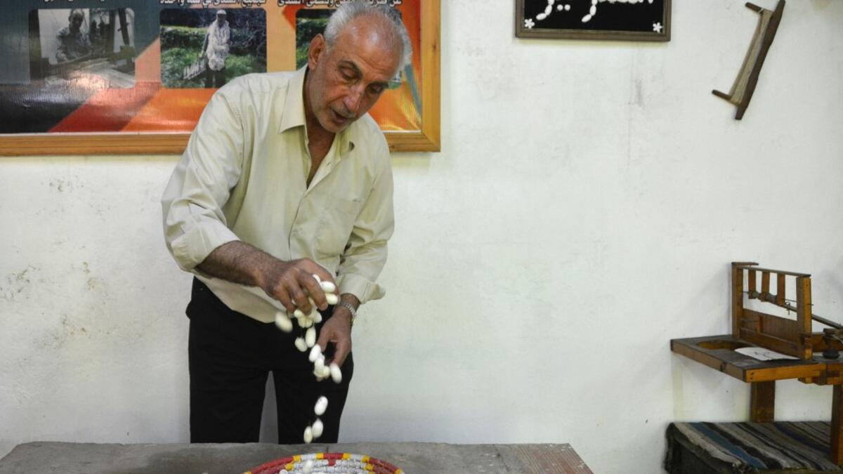 In the green hills of Deir Mama, Saud, his wife and three sons have been making silk for decades. They would raise silk worms in the spring, watching them munch on mulberry tree leaves and slowly build their thick cocoons, before spinning the thread and weaving those coils into fine cloth. MAHER AL MOUNES / AFP