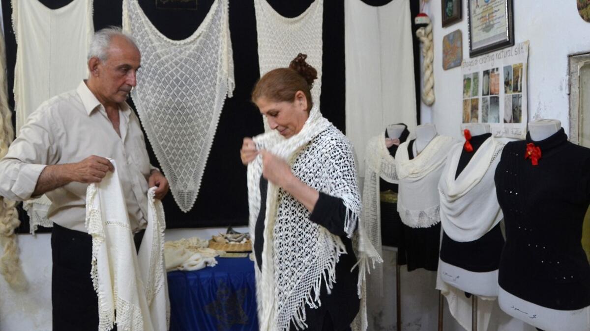 Muhammad Saud, a 65-year-old Syrian silk farmer, handweaves silk threads on a loom at his home workshop in the village of Deir Mama, in west-central Syria on June 22, 2020. MAHER AL MOUNES / AFP