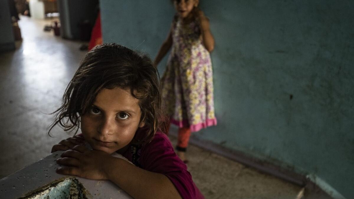 A girl looks on in the stairwell of a school building where Syrians -- displaced from the area of Ras al-Ain by the Turkish offensive on the northeast -- are staying in the city of Hasakah, on June 30, 2020. Delil SOULEIMAN / AFP