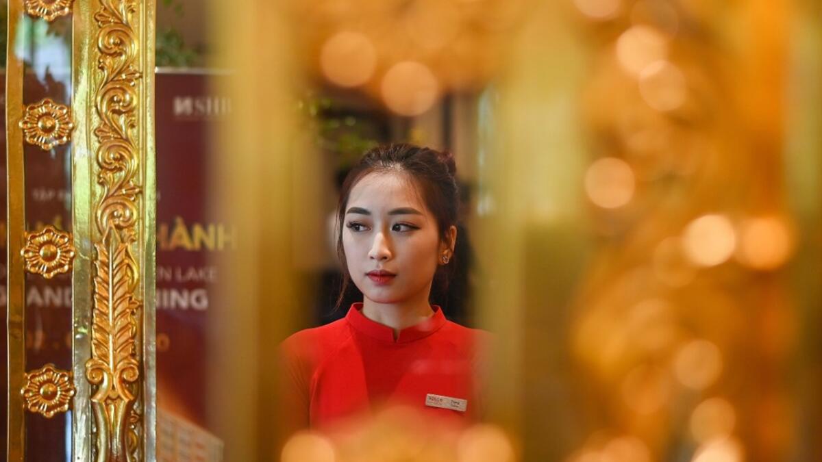 A staff member waits to welcome guests in the lobby of the newly-inaugurated Dolce Hanoi Golden Lake hotel, the world's first gold-plated hotel, in Hanoi on July 2, 2020. Manan VATSYAYANA / AFP