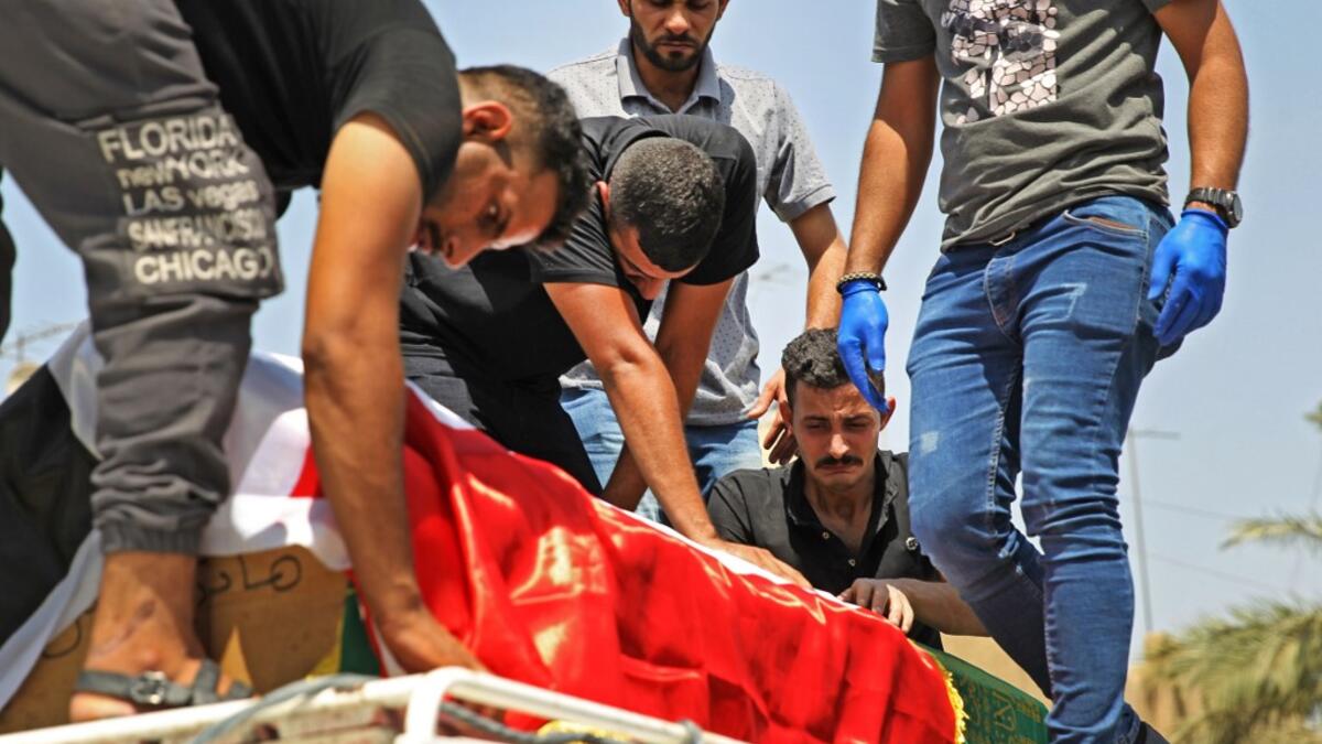 Mourners transport the coffin of slain Iraqi jihadism expert Hisham al-Hashemi, who was shot dead yesterday outside his house in the Iraqi capital, during his funeral in Baghdad’s Zayouna district on July 7, 2020. Hashemi was an authoritative voice on Sunni jihadist factions including the Islamic State group, but was also frequently consulted by media and foreign governments on domestic Iraqi politics and Shiite armed groups.