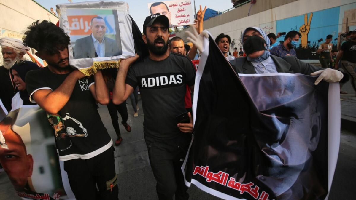 Iraqi demonstrators stage a symbolic funeral for slain Iraqi jihadism expert Hisham al-Hashemi, who was shot dead yesterday outside his house in the Iraqi capital, on July 7, 2020 at Baghdad's Tahrir square. The killing of the 47-year-old prominent expert has stirred fears Iraq is entering a dark and violent phase, as boiling tensions between pro-Iran factions and the government reach new heights. AHMAD AL-RUBAYE / AFP