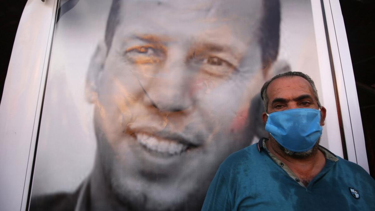 An Iraqi demonstrator wearing a face mask to protect agaisnt the Covid-19 coronavirus, attends a symbolic funeral for slain Iraqi jihadism expert Hisham al-Hashemi, who was shot dead yesterday outside his house in the Iraqi capital, on July 7, 2020 at Baghdad's Tahrir square. The killing of the 47-year-old prominent expert has stirred fears Iraq is entering a dark and violent phase, as boiling tensions between pro-Iran factions and the government reach new heights. AHMAD AL-RUBAYE / AFP
