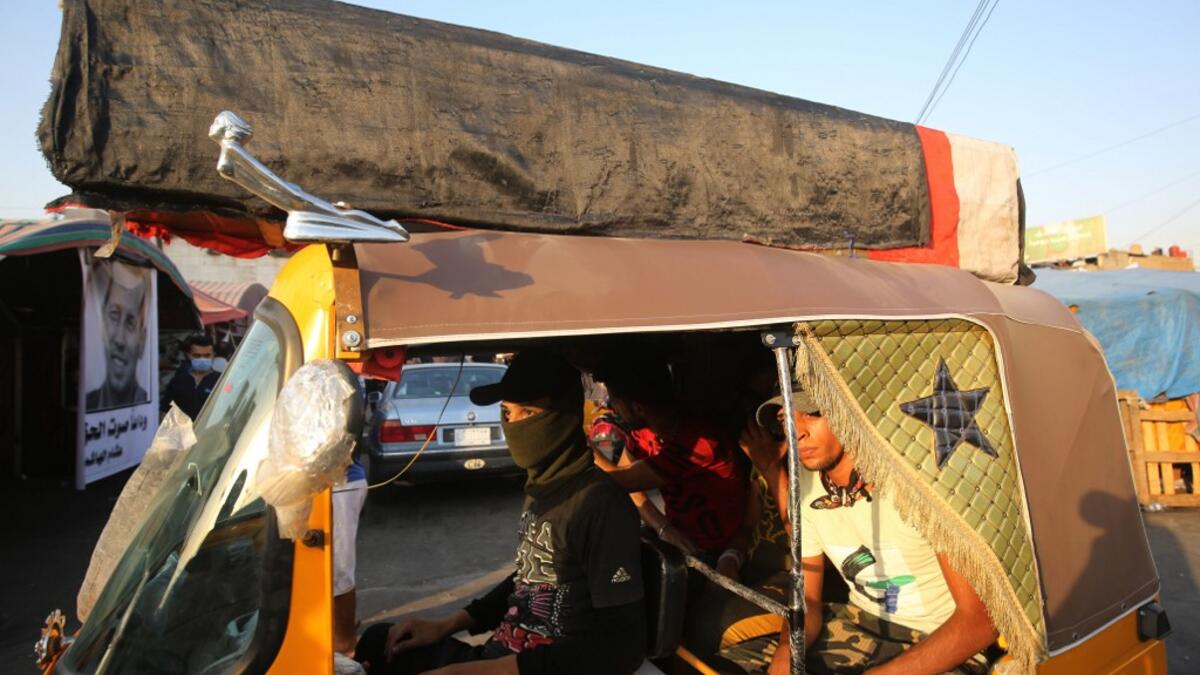 Iraqi demonstrators attend a symbolic funeral for slain Iraqi jihadism expert Hisham al-Hashemi, who was shot dead yesterday outside his house in the Iraqi capital, on July 7, 2020 at Baghdad's Tahrir square. The killing of the 47-year-old prominent expert has stirred fears Iraq is entering a dark and violent phase, as boiling tensions between pro-Iran factions and the government reach new heights. AHMAD AL-RUBAYE / AFP