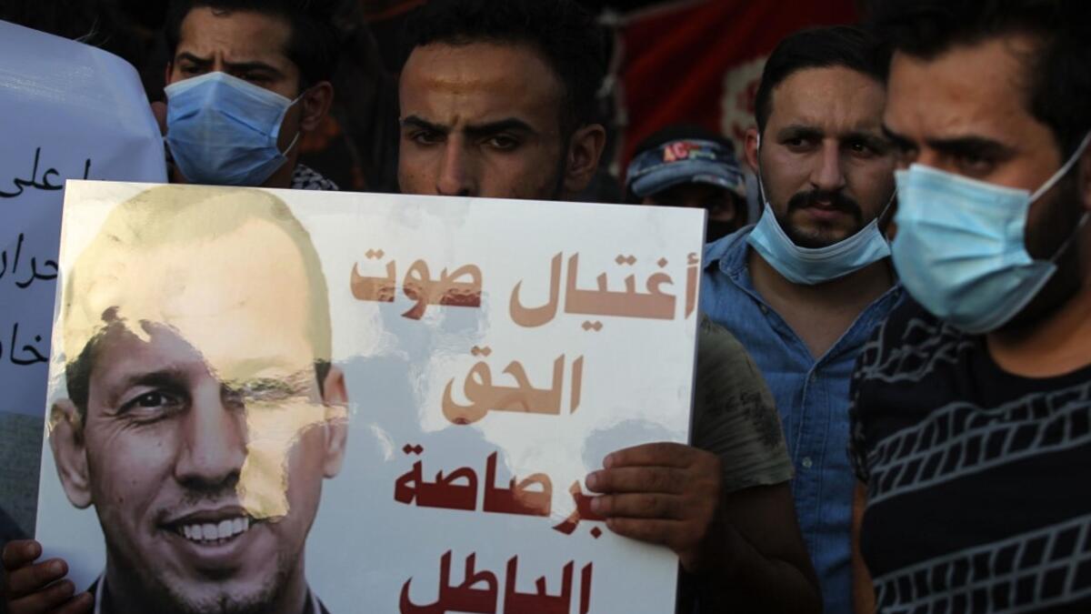 Iraqi demonstrators attend a symbolic funeral for slain Iraqi jihadism expert Hisham al-Hashemi, who was shot dead yesterday outside his house in the Iraqi capital, on July 7, 2020 at Baghdad's Tahrir square. Slogan reads in Arabic: "the voice of right killed with the bullet of wrong". The killing of the 47-year-old prominent expert has stirred fears Iraq is entering a dark and violent phase, as boiling tensions between pro-Iran factions and the government reach new heights. AHMAD AL-RUBAYE / AFP