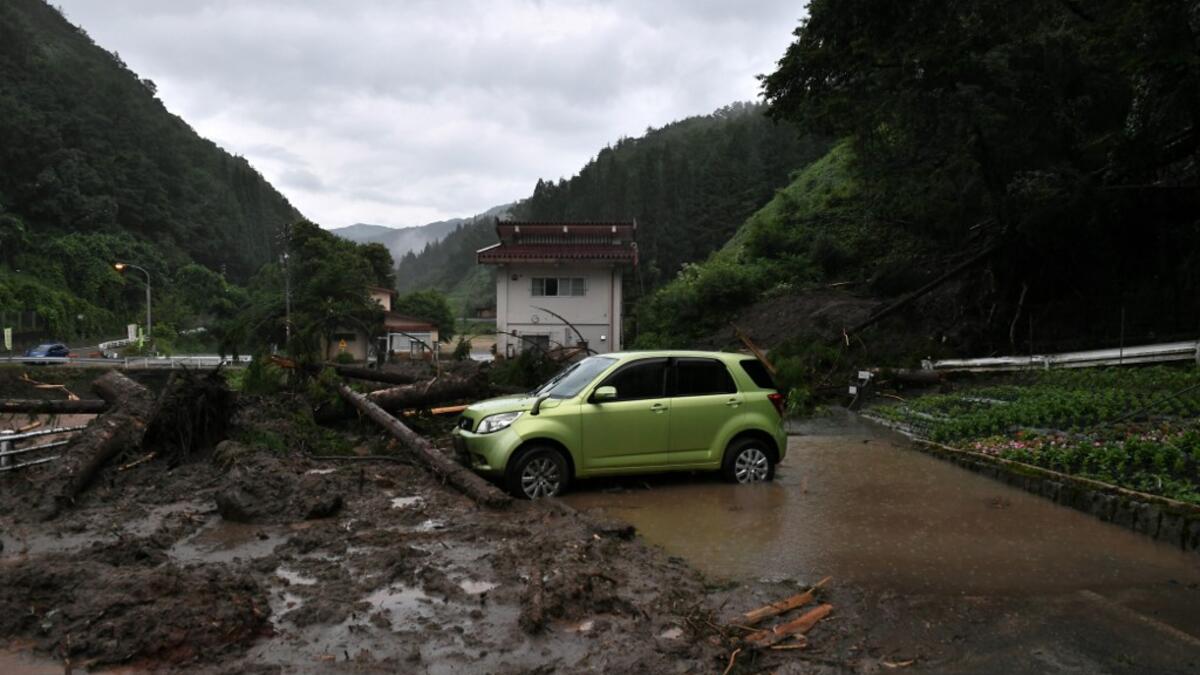 A car is seen among debris littering a village following heavy rains and flooding in the village of Takayama, Gifu prefecture on July 9, 2020. Japanese emergency services and troops were scrambling to reach thousands of homes cut off by devastating flooding and landslides that have killed dozens and caused widespread damage. Philip FONG / AFP