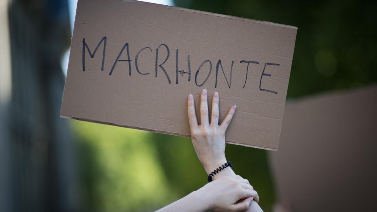 A protester holds a sign reading "Macrhonte", a play on words on the French President's name and the French word for "shame" during a demonstration called by feminist movements in Nantes, western France, on July 10, 2020, to denounce the nomination of French Interior Minister, facing rape accusations and French Justice Minister who criticised the #MeToo movement against sexual harassment. LOIC VENANCE / AFP