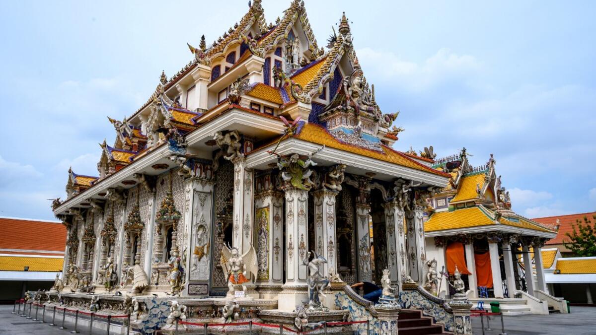 This photograph taken on July 14, 2020 shows the Wat Pariwat Buddhist temple in Bangkok. Wat Pariwat, also known as "the David Beckham Temple", is decorated with statues of superheroes and comic characters as well as mythical and imaginary creatures. A golden-plated sculpture of the English football player holding the base of a Buddha statue in one of the buildings gives the temple its nickname. Mladen ANTONOV / AFP