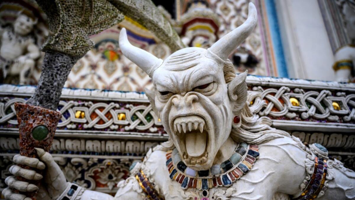 This photograph taken on July 14, 2020 shows a statue of an imaginary creature outside the Wat Pariwat Buddhist temple in Bangkok. Wat Pariwat, also known as "the David Beckham Temple", is decorated with statues of superheroes and comic characters as well as mythical and imaginary creatures. A golden-plated sculpture of the English football player holding the base of a Buddha statue in one of the buildings gives the temple its nickname.