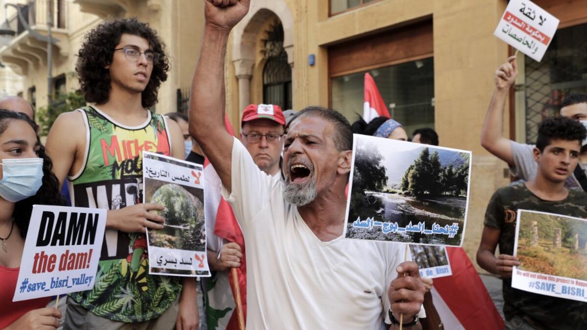 Demonstrators hold placards as they take part in a rally in front of the World Bank offices in the downtown district of the Lebanese capital Beirut on July 25, 2020, to protest against the Bisri dam project, partly financed by the World Bank. The government says the Bisri dam is vital to tackling chronic water shortages. But activists say it will ravage most of the region's farmland and historic sites, and they also fear the consequences of building it on a seismic fault line.  ANWAR AMRO / AFP