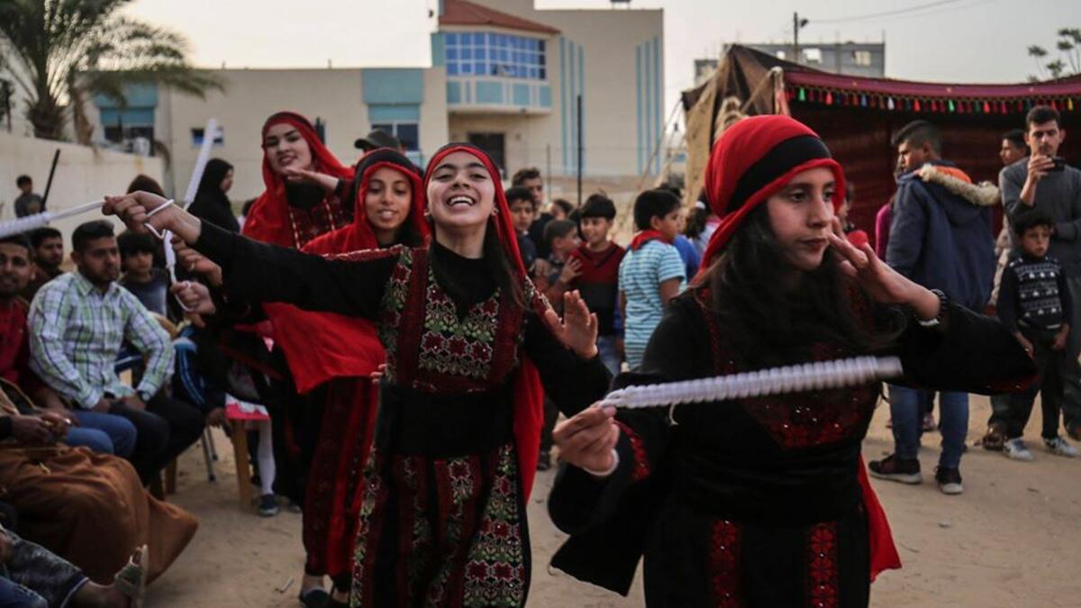 Palestinian girls dressed in traditional clothing dance during an event celebrating their culture in Khan Yunis, in the southern Gaza Strip. (AFP)