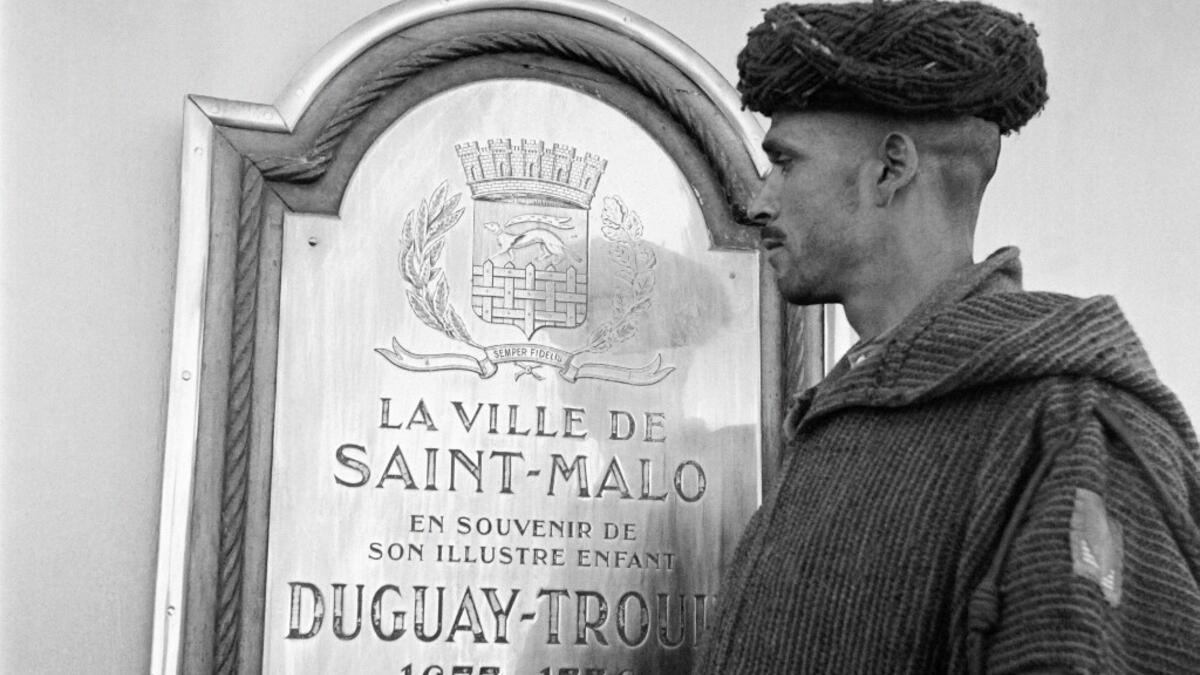 A Moroccan goumier (indigenous Moroccan soldiers who served in the French Army) looks at a commemmorative plate, under a sign where is written "patrie", aboard the French Navy light cruiser Duguay-Trouin in October 1945, before disembarking in the port of Casablanca. AFP
