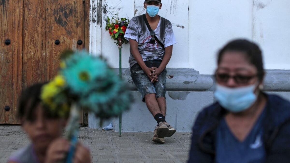 Catholic faithfuls wear face masks as a preventive measure against the spread of the novel coronavirus, COVID-19, during the opening of the ten-day celebration of the Santo Domingo de Guzman festival, outside the Las Sierritas de Santo Domingo church in Managua, on August 1, 2020. Despite the Catholic Church cancelling all religious activities due to the coronavirus pandemic, devotees gathered outside the church for the celebration. Inti OCON / AFP