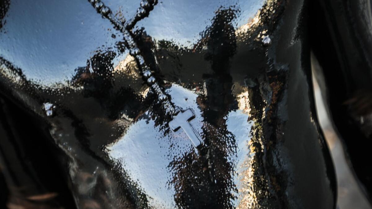 A Catholic faithful smeared in burnt oil and wearing a cross takes part in the opening of the ten-day celebration of the Santo Domingo de Guzman festival, outside the Las Sierritas de Santo Domingo church in Managua, on August 1, 2020 amid the COVID-19 novel coronavirus pandemic. Despite the Catholic Church cancelling all religious activities due to the coronavirus pandemic, devotees gathered outside the church for the celebration. Inti OCON / AFP