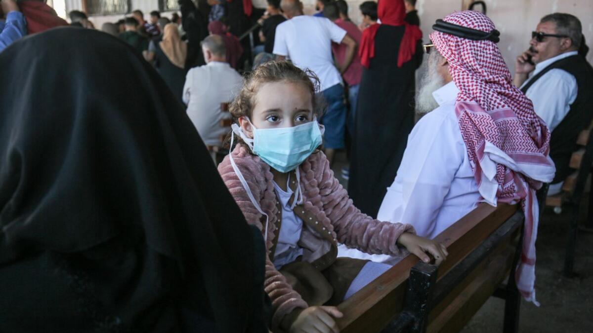 Palestinians wait to cross to the Egyptian side of Rafah border crossing after months of closure due to the coronavirus pandemic in the southern Gaza Strip, on August 11, 2020. SAID KHATIB / AFP