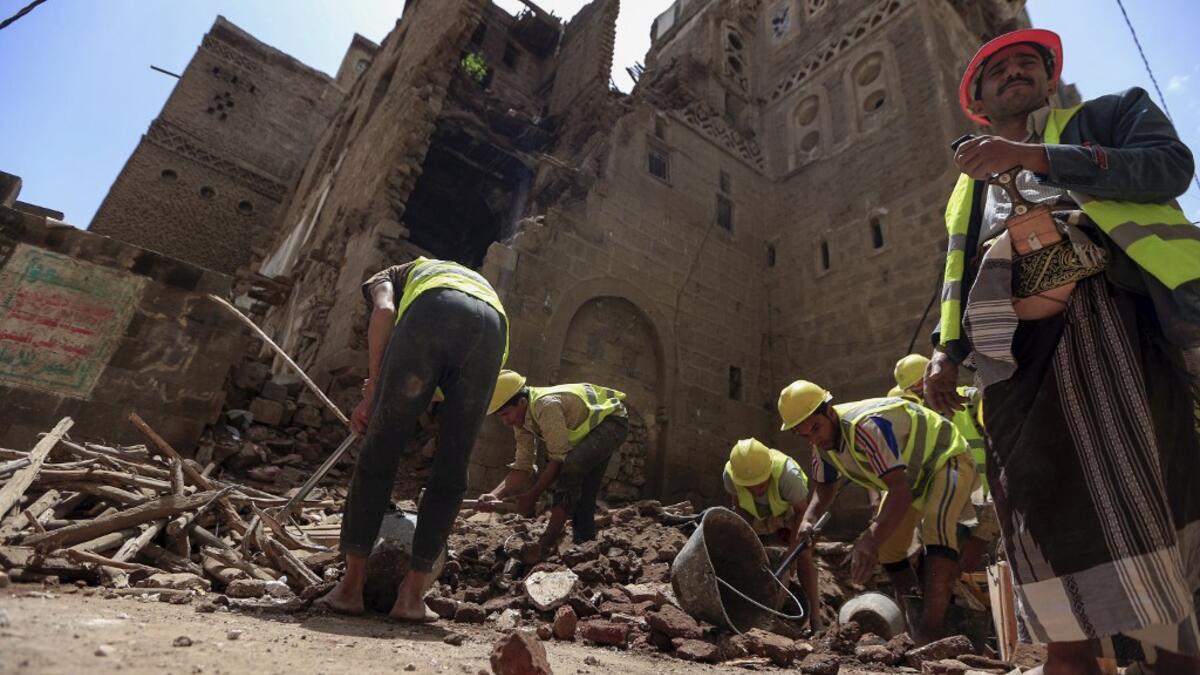 Yemeni labourers remove the rubble ahead of restoration works on the site of a collapsed UNESCO-listed building following heavy rains, in the old city of the Yemeni capital Sanaa, on August 12, 2020. Flash floods triggered by torrential rains have killed at least 172 people across Yemen over the past month, damaging homes and UNESCO-listed world heritage sites, officials said. Mohammed HUWAIS / AFP