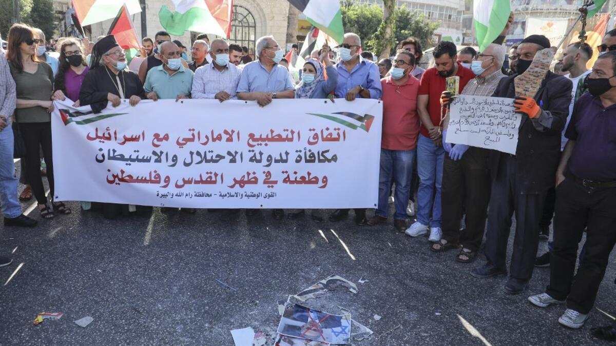 Palestinian protesters lift a banner during a demonstration against the Emirati-Israeli agreement in Ramallah in the occupied West Bank, on August 15, 2020. ABBAS MOMANI / AFP