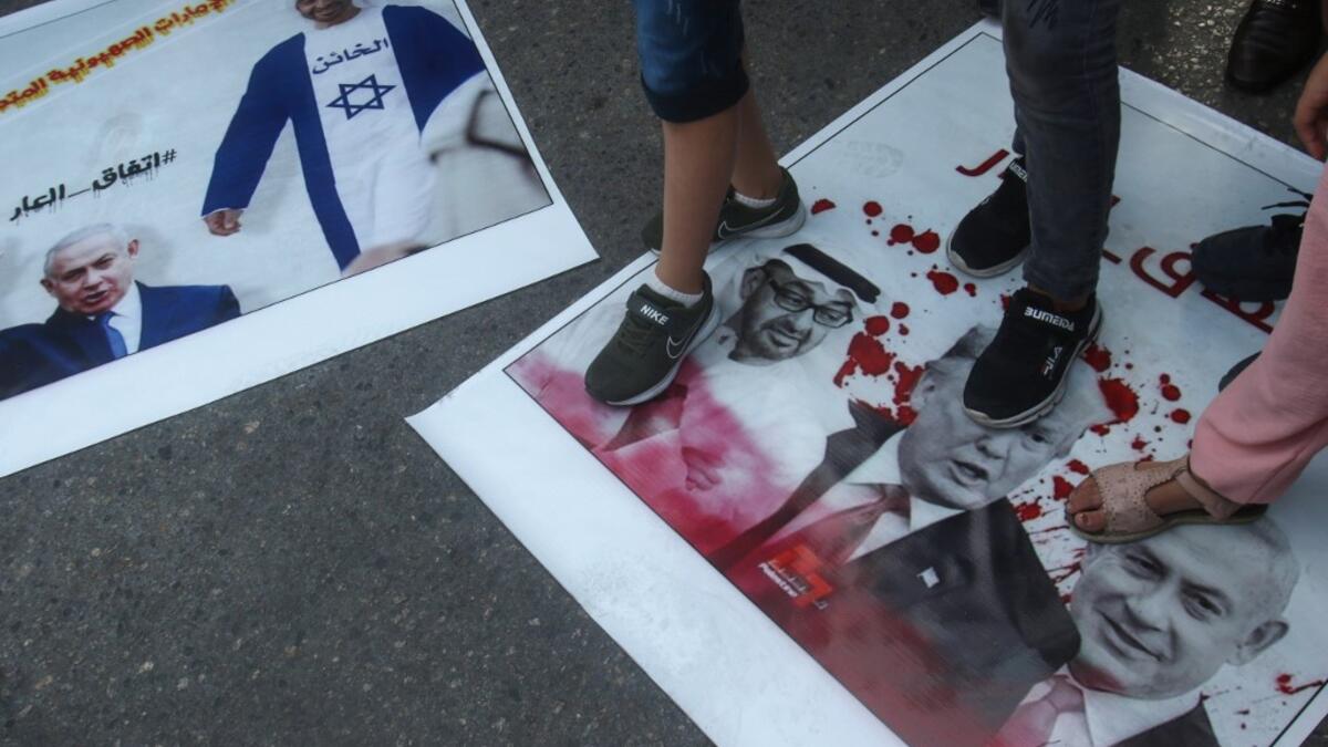 Palestinian refugees tread on pictures of Abu Dhabi Crown Prince Sheikh Mohammed bin Zayed Al Nahyan, US President Donald Trump, and Israeli Prime Minister Benjamin Netanyahu, during a demonstration against the Emirati-Israeli agreement in the Lebanese southern coastal city of Tyre, on August 15, 2020. Mahmoud ZAYYAT / AFP