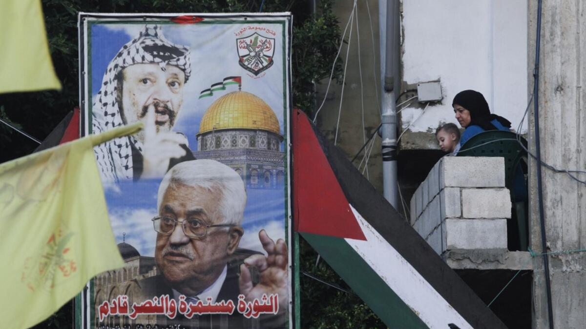 A woman carrying a child looks out her balcony during a demonstration in the Bass Palestinian refugee camp in the Lebanese southern coastal city of Tyre against the Emirati-Israeli agreement, on August 15, 2020. Mahmoud ZAYYAT / AFP