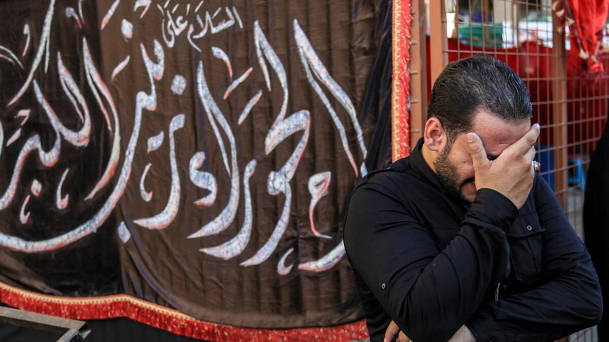 A man weeps on the side of a procession commemorating the entry of Imam Hussein and his family and retinue into Karbala, as Shiite Muslims mark the Ashura period in Iraq's central holy shrine city on August 22, 2020. Ashura is a period of mourning in remembrance of the seventh-century martyrdom of Prophet Mohammad's grandson Imam Hussein, who was killed in the battle of Karbala in modern-day Iraq, in 680 AD. Mohammed SAWAF / AFP