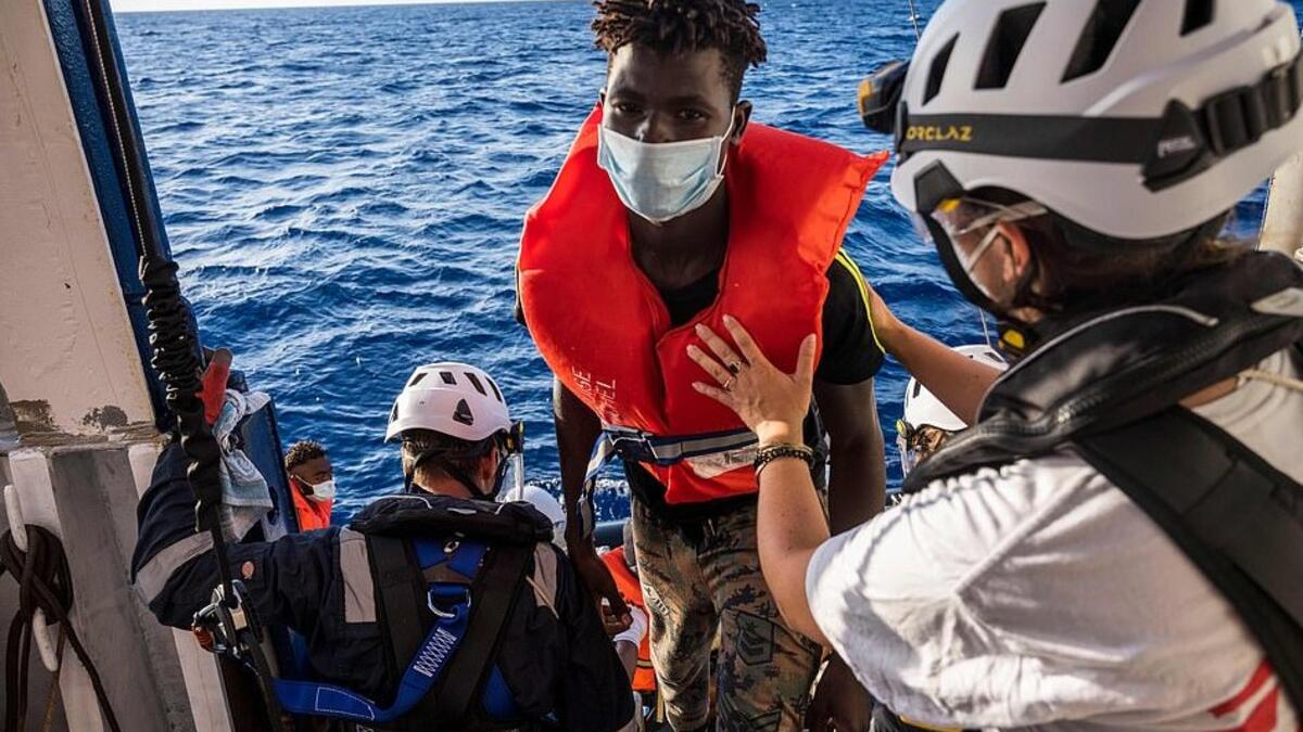 The Louise Michel last night remained dangerously overloaded and was said to be 'losing its balance' but other rescue ships have started to help get migrants off the boat (AFP)