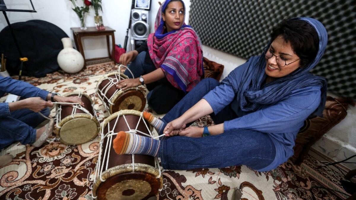 (L to R) Pippeh drummer Malihe Shahinzadeh and drummer Faezeh Mohseni practise together with other band members at a home studio called the "Dingo room" in Iran's southern Gulf port city of Bandar Abbas on April 30, 2019. ATTA KENARE / AFP