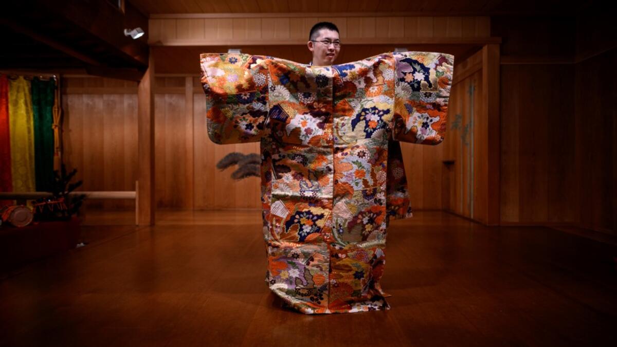 This photo taken on July 29, 2020 shows performer Kennosuke Nakamori posing for a photo with a costume after an interview with AFP at the Kamakura Noh Theatre in the town of Kamakura in Kanagawa Prefecture, about one hour southwest of Tokyo. Philip FONG / AFP