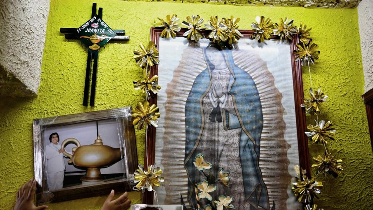 Mexican criminologist Maira de Rosas Silva puts a portrait of her mother, Mexican nurse Juana Silva Isidoro, who died of the novel coronavirus, COVID-19, on an altar in her house in Xochimilco neighbourhood in Mexico City on August 16, 2020. Global deaths from the coronavirus have almost reached on September 25, 2020 the grim threshold of one million. Around one-third of fatalities were in Latin America, where countries with overstretched medical resources are preparing for a further onslaught. Alfredo ESTR