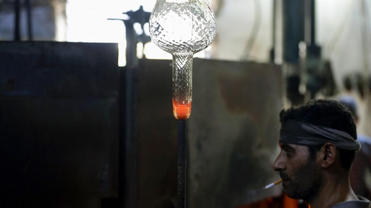 A glassblower forms glass at factory, which is recycling the broken glass as a result of the Beirut explosion, in the northern Lebanese port city of Tripoli on August 25, 2020. The August 4 port explosion ripped through countless glass doors and windows when it laid waste to whole Beirut neighbourhoods, killing at least 190 people and wounding thousands more. Volunteers, non-governmental groups and entrepreneurs salvaged a fraction of the tonnes of broken glass that littered the streets, some of it through