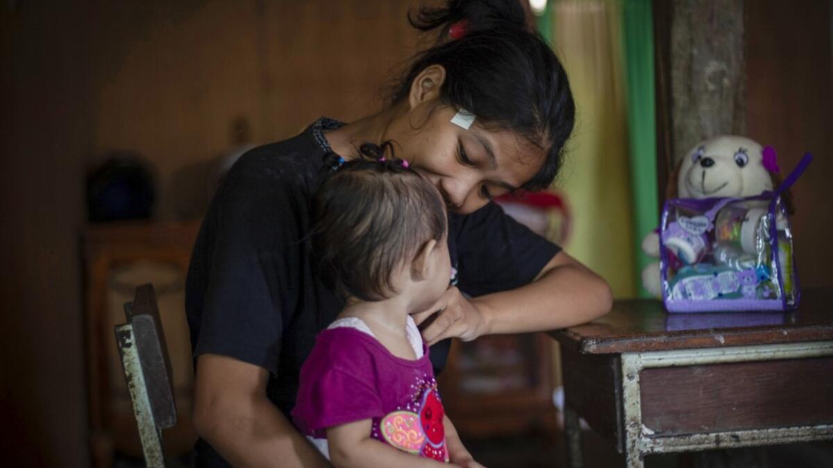 This picture taken on February 9, 2019 shows Nurlina, 19, who got married in 2017, holding her daughter in the village of Galung Lombok in West Sulawesi. Child marriage has long been common in traditional communities from the Indonesian archipelago to India, Pakistan and Vietnam, but numbers had been decreasing as charities made inroads by encouraging access to education and women's health services. YUSUF WAHIL / AFP